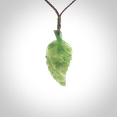 A delicate green jade fern leaf pendant with an adjustable neck cord. Green stone fern leaf necklace with adjustable cord. Delivery included.